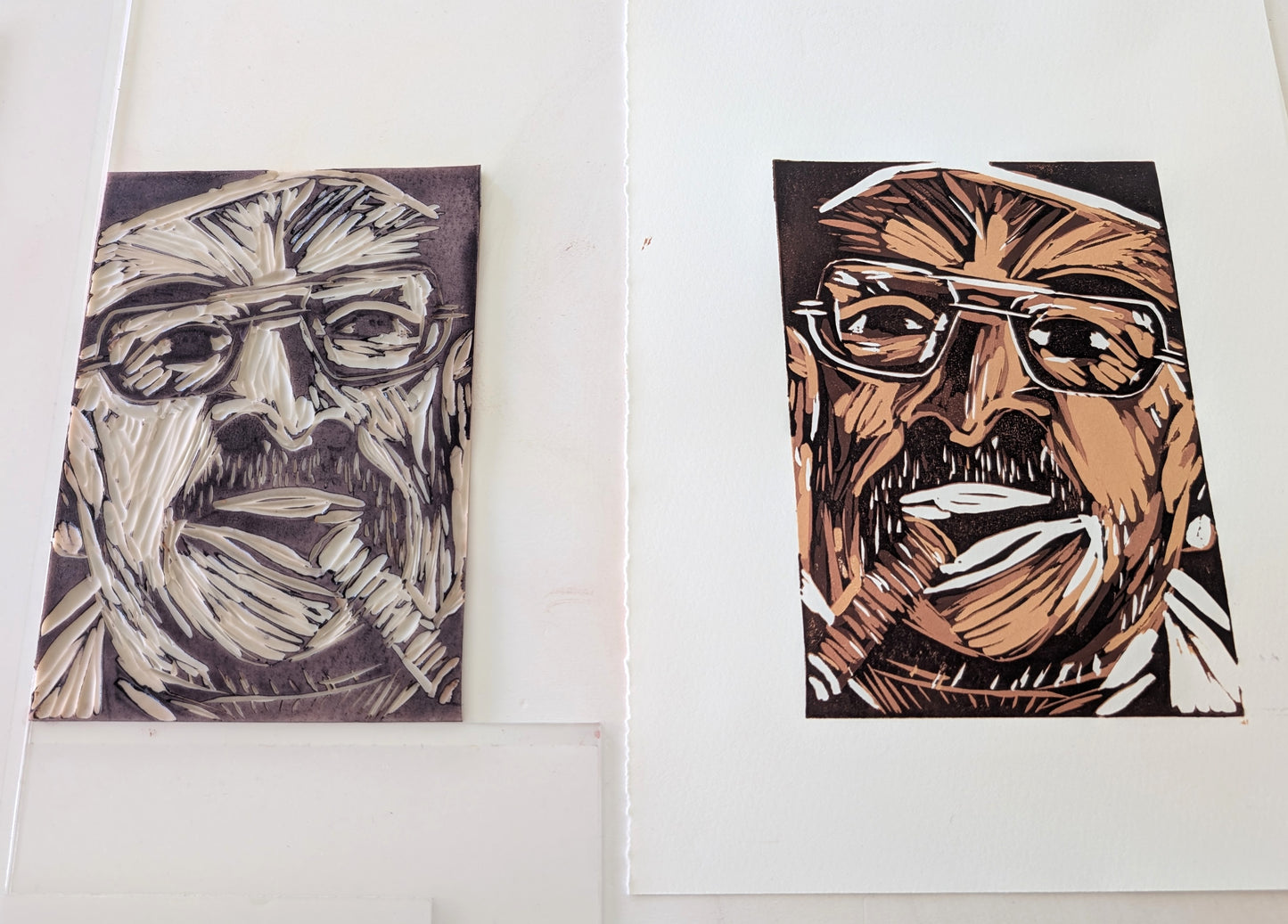 An art print of a man with glasses and a cigar, alongside the lino block which created it, on a white background.